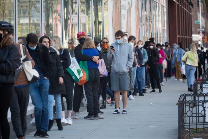 People wearing face masks wait in line to do shopping at a Whole Foods store Coovid 19 New York 14 Apr